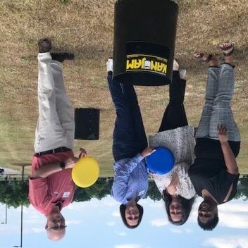 Four people standing with frisbees